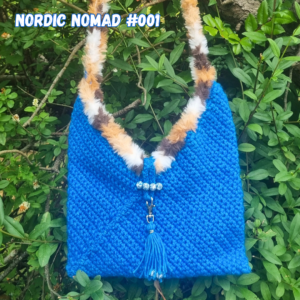 Nordic Nomad #001 er en håndhæklet crossbody taske, designet og håndhæklet af Eva. Med specialdesignet lukning og kun ét unikt eksemplar fra EJ Designs.